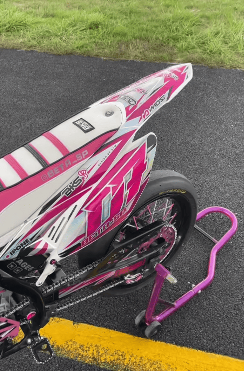 Arrière d'une moto rose et blanche avec housse de selle BKS blanche et rose