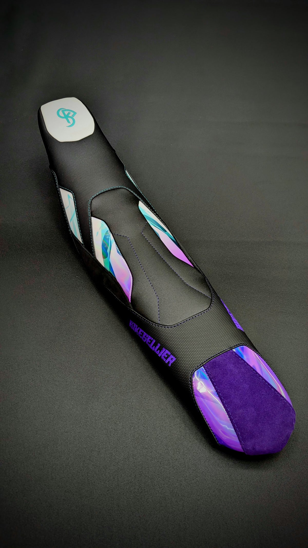 Housse de selle BKS noire à inserts holographiques et violets, photo studio